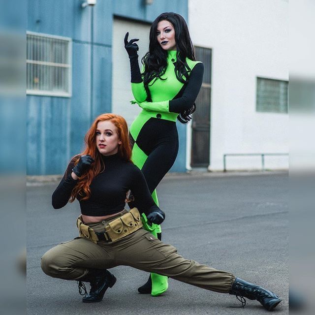 two women dressed in costumes posing for the camera, one with her hand on her hip