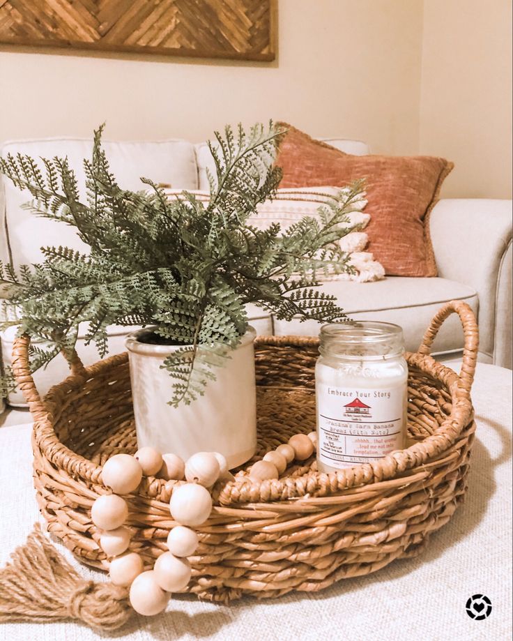 a wicker basket holding a potted plant and candle