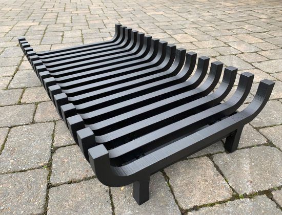 a black bench sitting on top of a brick sidewalk