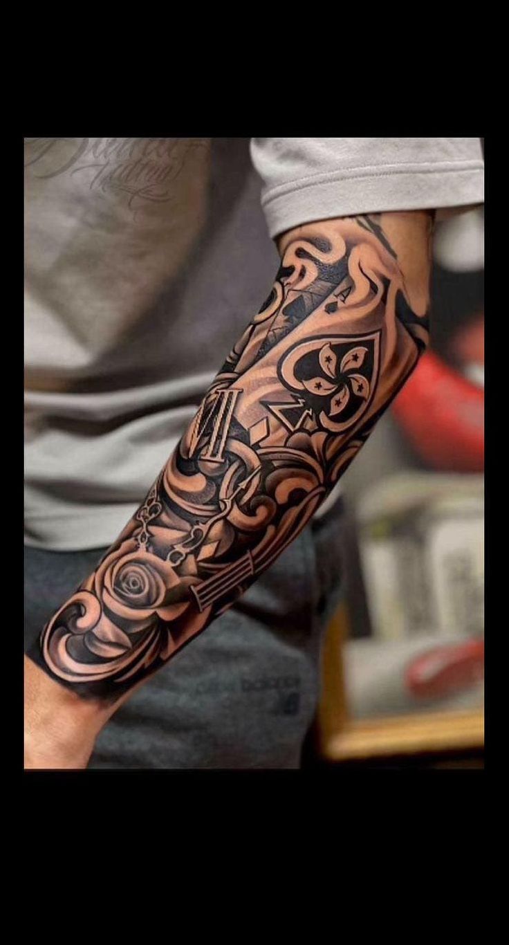 a man's arm with an intricate tattoo design on the arm and shoulder,