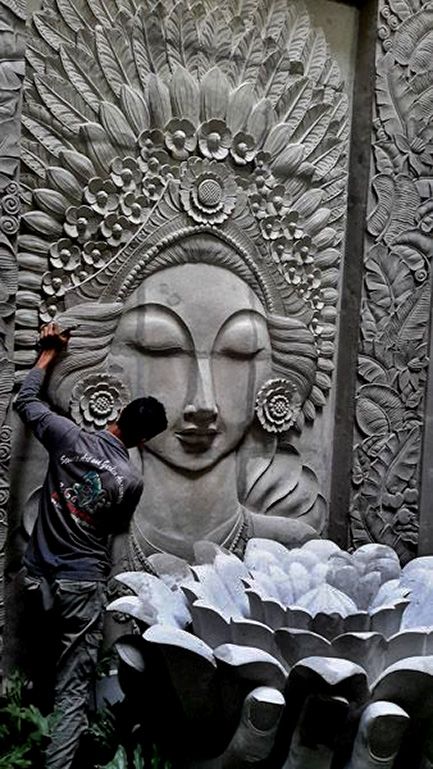 a man standing next to a large statue