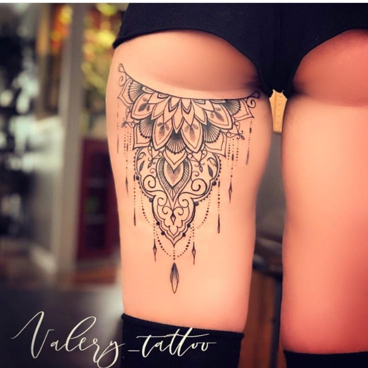 a woman's thigh with an intricate tattoo on it