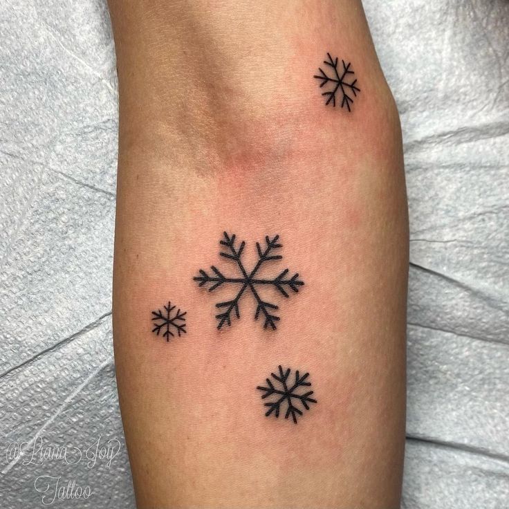 a snowflake tattoo on the right arm and left leg, with four small snowflakes