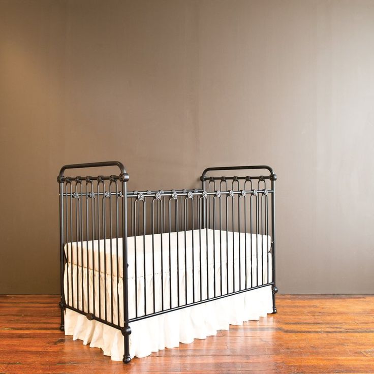 two cribs sitting on top of a hard wood floor next to a wall