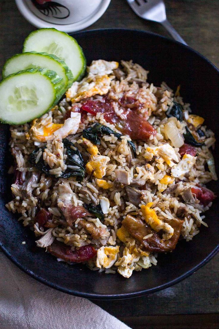 a black bowl filled with rice and vegetables