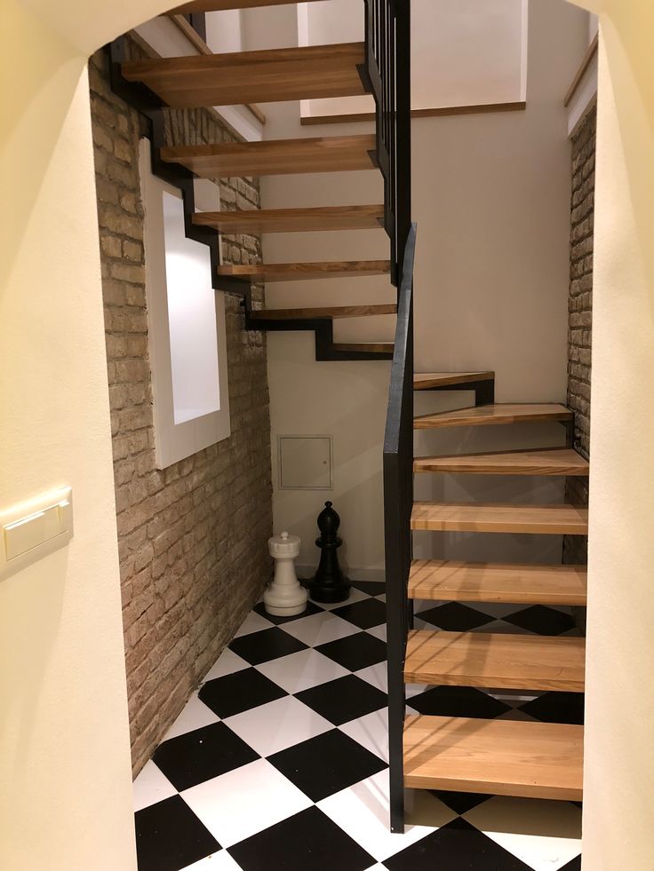 the stairs are made of wood and have black and white checkered tiles on them