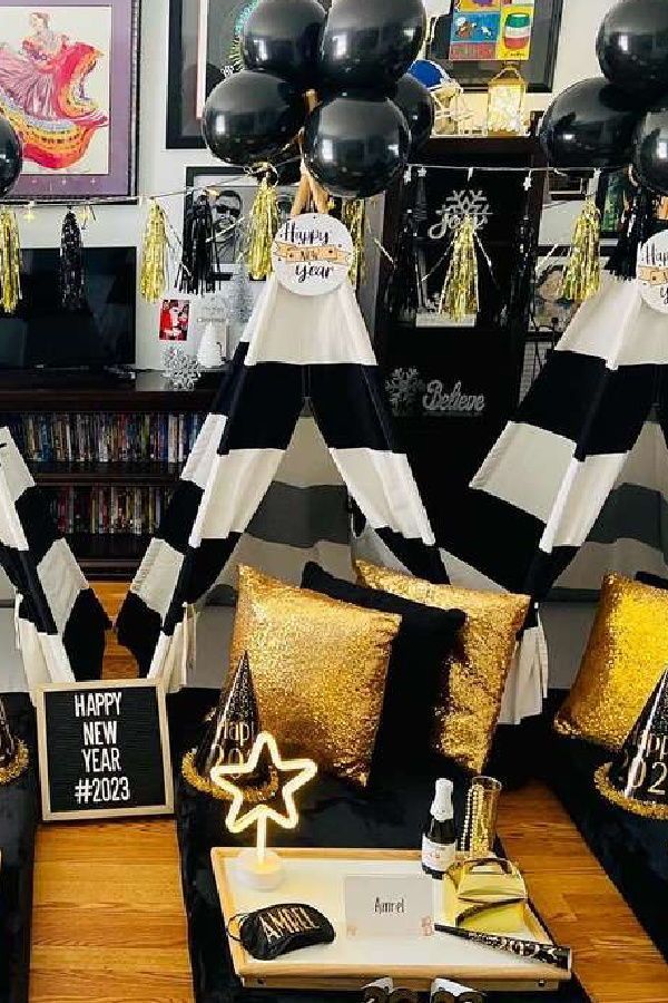 black and white party decorations with gold sequins on the pillows in front of them