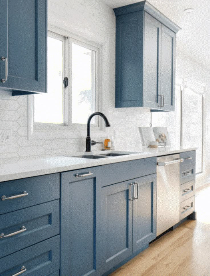 a kitchen with blue cabinets and wood floors