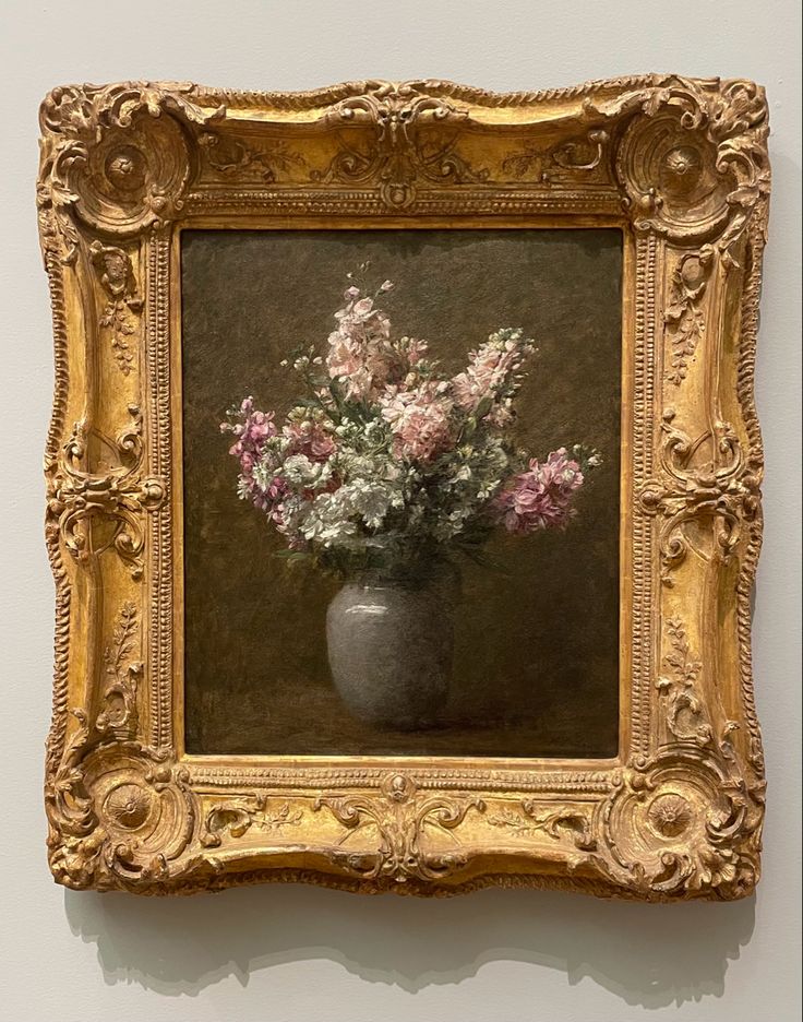 a painting of flowers in a vase on a wall with a gold frame around it