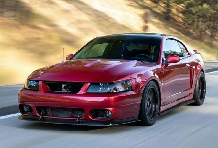 a red sports car driving down the road