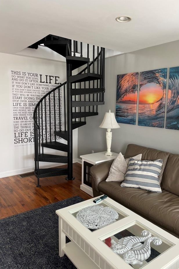 a living room with a couch, coffee table and spiral stair case in it's center