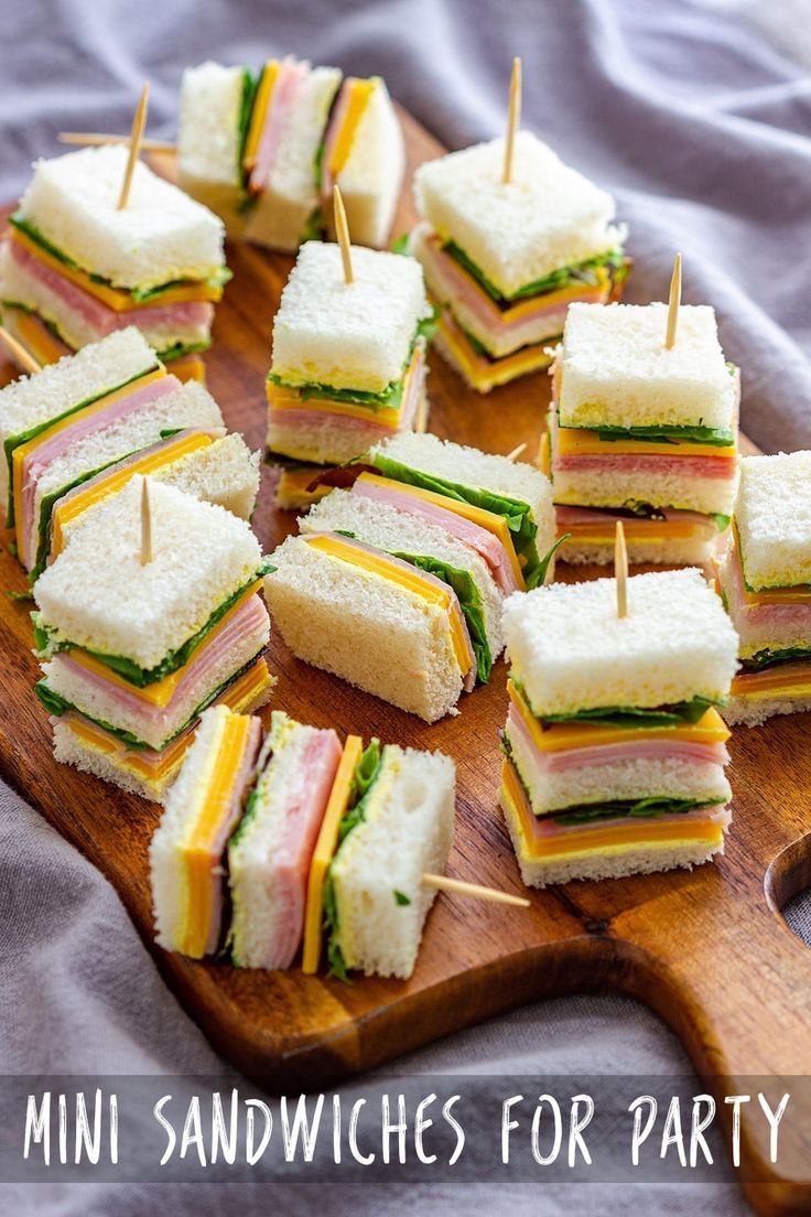 mini sandwiches are arranged on a cutting board