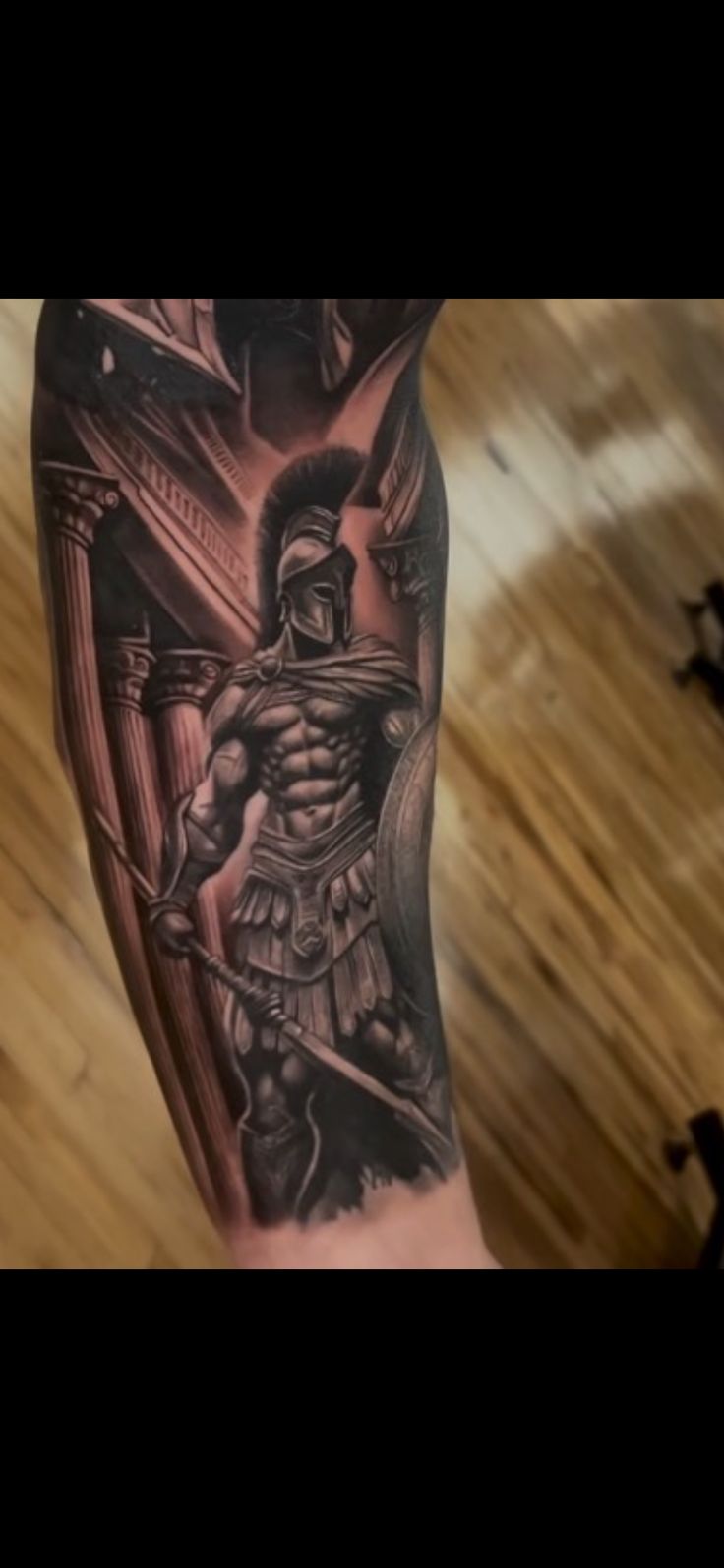 a man's leg with a spartan tattoo on it