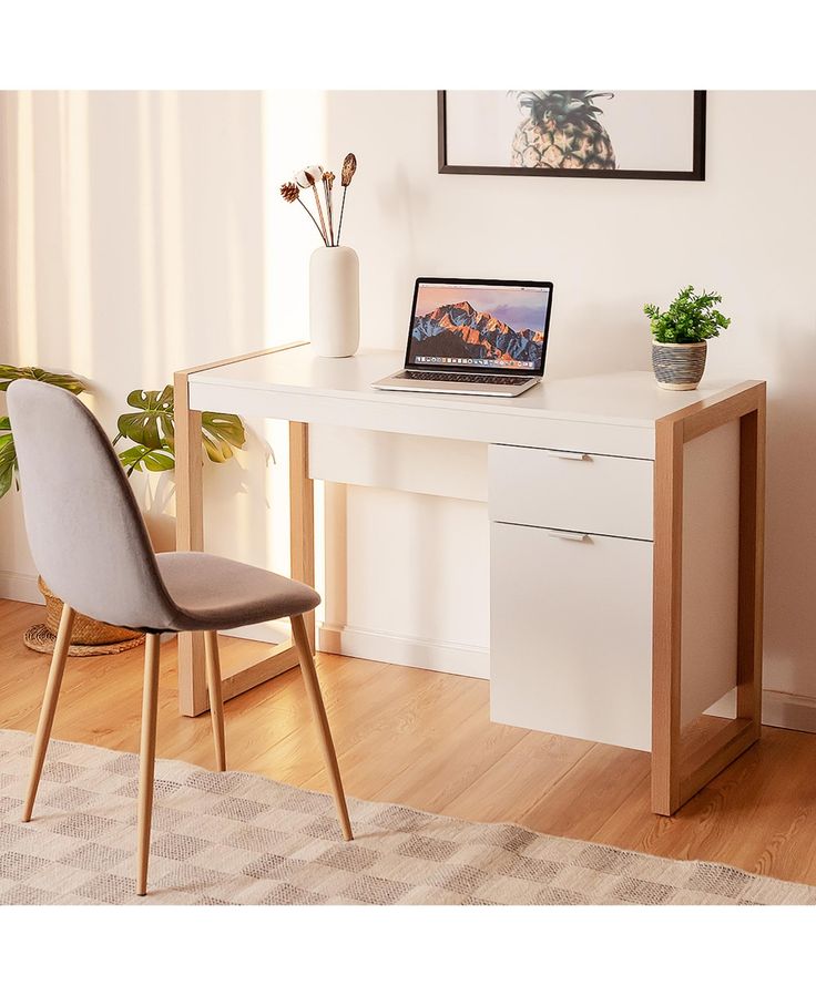 a laptop computer sitting on top of a white desk next to a chair and potted plant