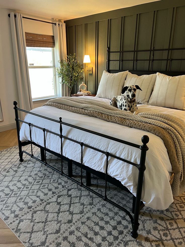 a dog sitting on top of a bed in a bedroom