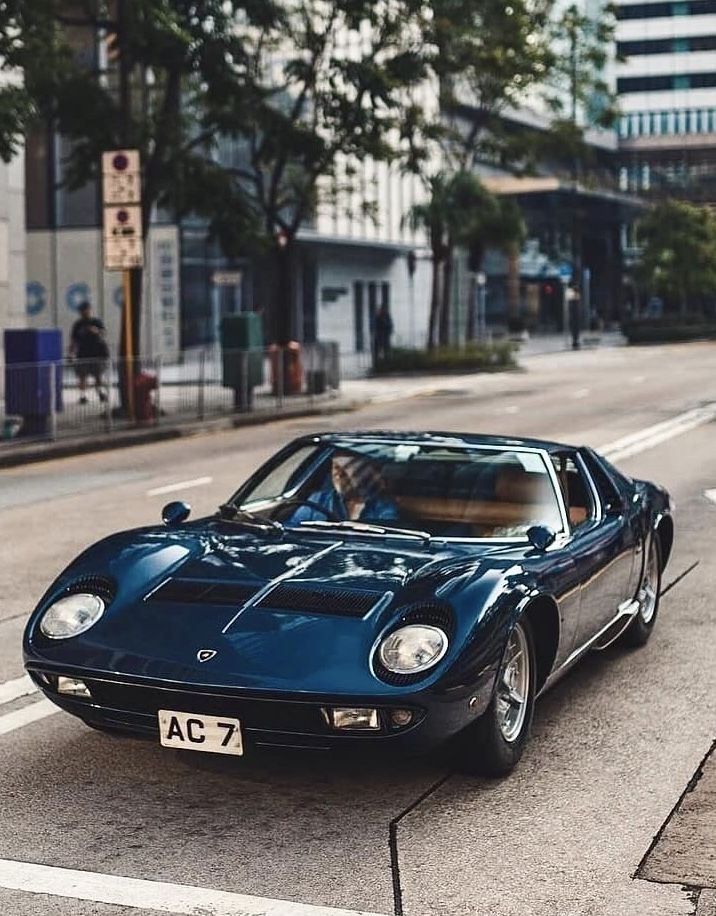 a blue sports car driving down the street