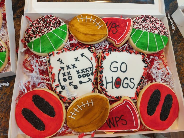 some decorated cookies in a box with writing on them and footballs, watermelons, and leaves