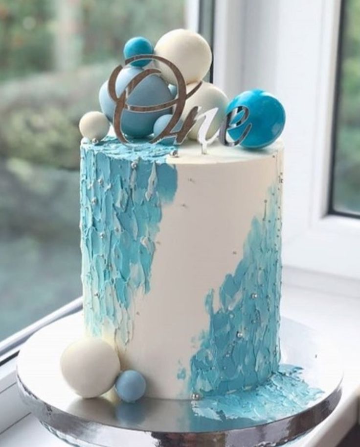 a blue and white cake sitting on top of a window sill