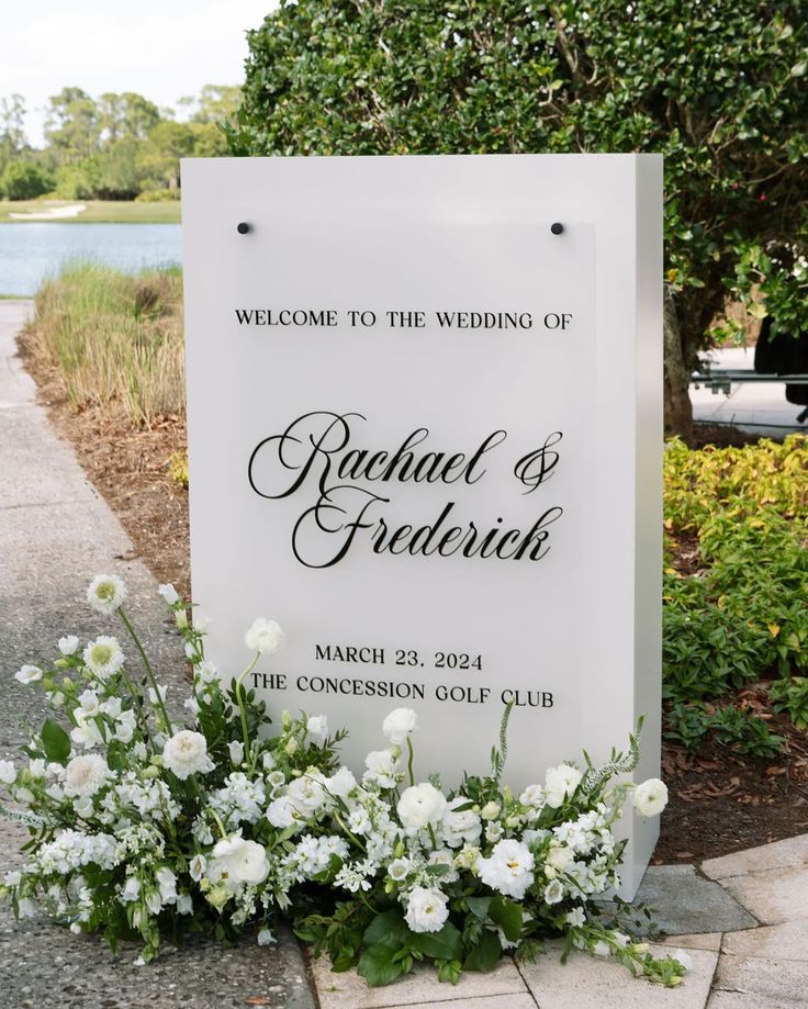 a welcome sign with white flowers and greenery