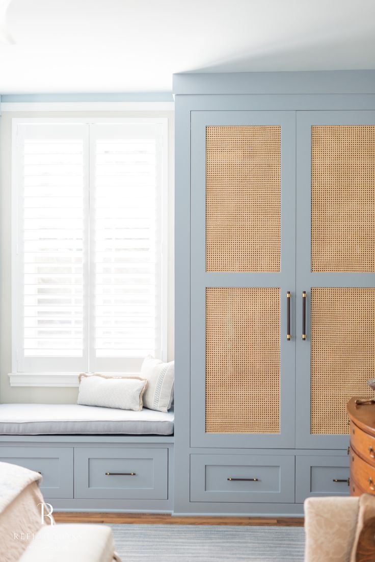 a bedroom with blue cabinets and white pillows