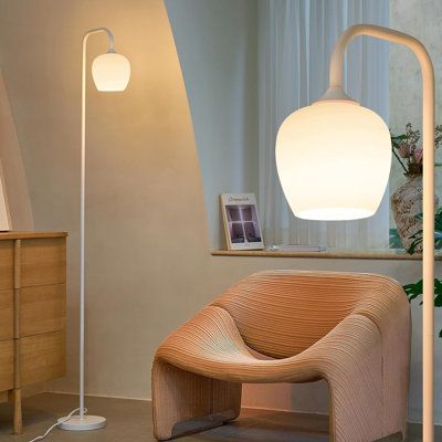 a lamp that is sitting on top of a table next to a chair and dresser