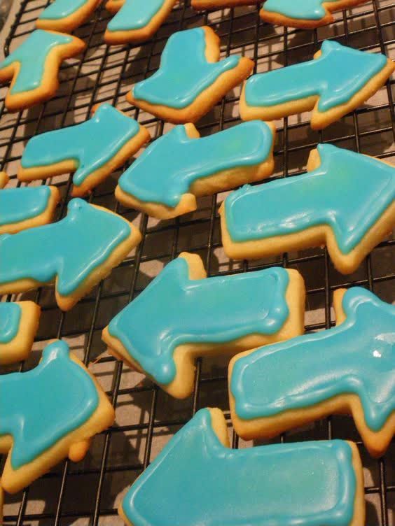 blue and yellow decorated cookies cooling on a rack in the sun with no frosting