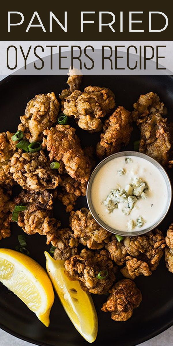 a plate with some fried oysters on it next to lemon wedges and dip