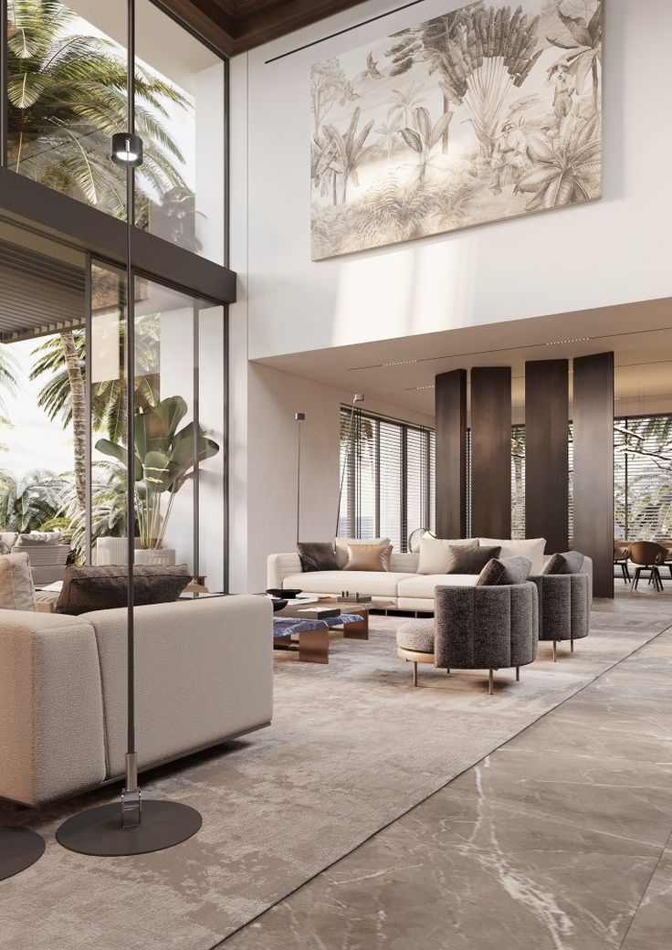 a living room filled with lots of furniture next to tall glass windows and palm trees