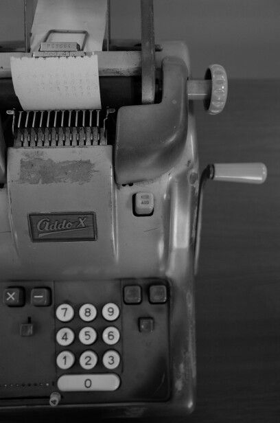 black and white photograph of an old typewriter with paper on the top, taken from above