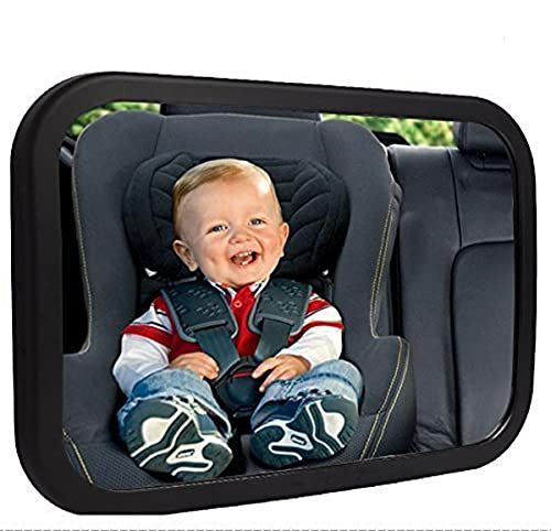 a baby sitting in a car seat with his mouth open and smiling at the camera