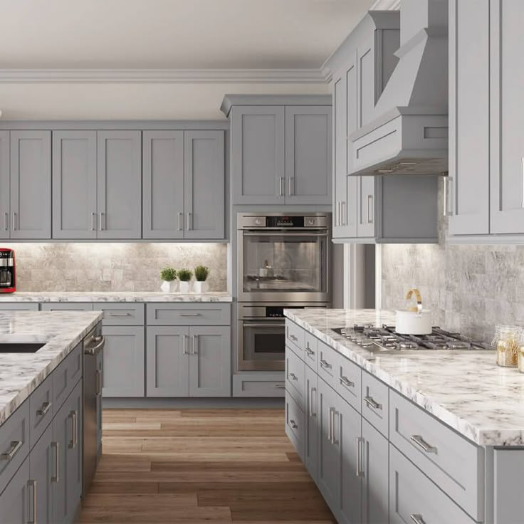 a large kitchen with gray cabinets and marble counter tops