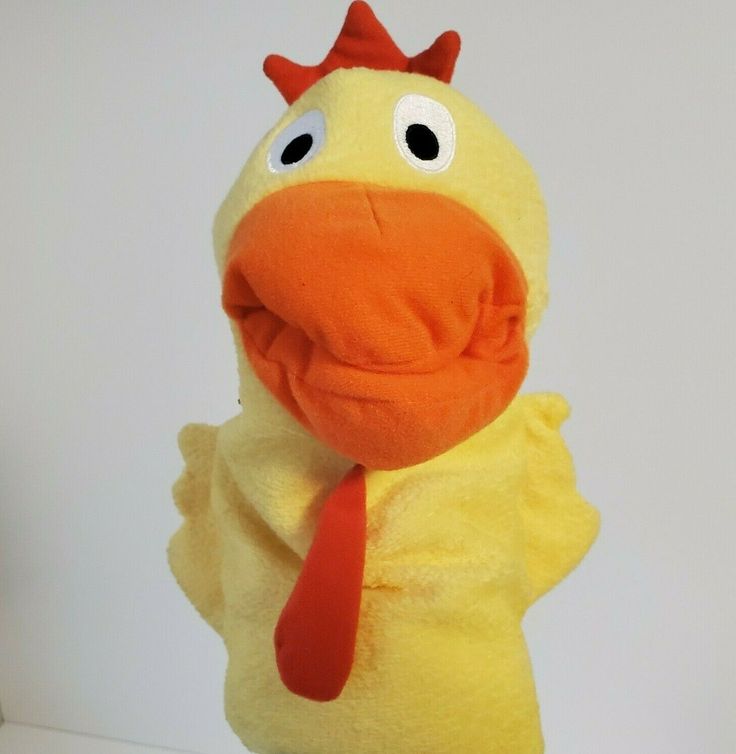 a yellow stuffed chicken with a red tie on it's head and eyes, standing upright