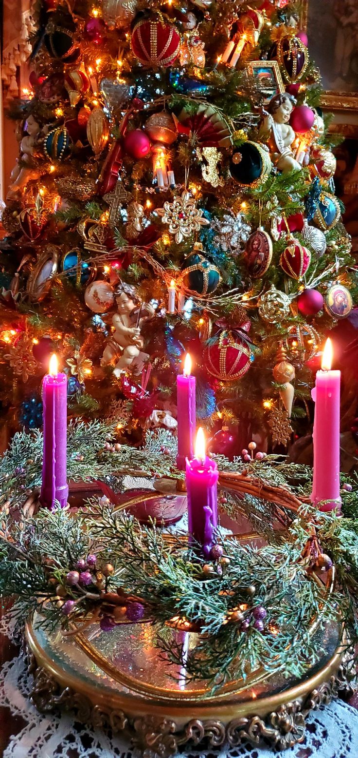 a christmas tree with lit candles in front of it