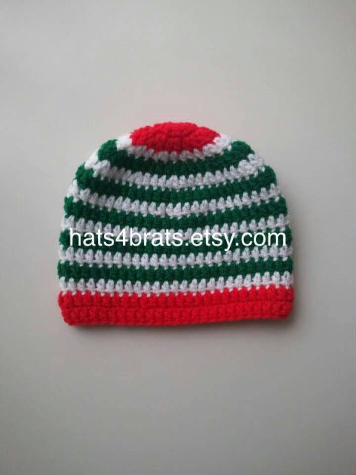 a red, white and green striped knitted hat on a gray surface with the words hats4bratsty com