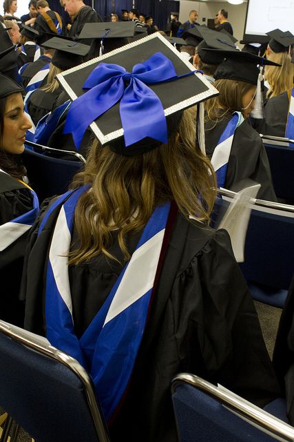 a group of people sitting in chairs wearing graduation caps and gowns