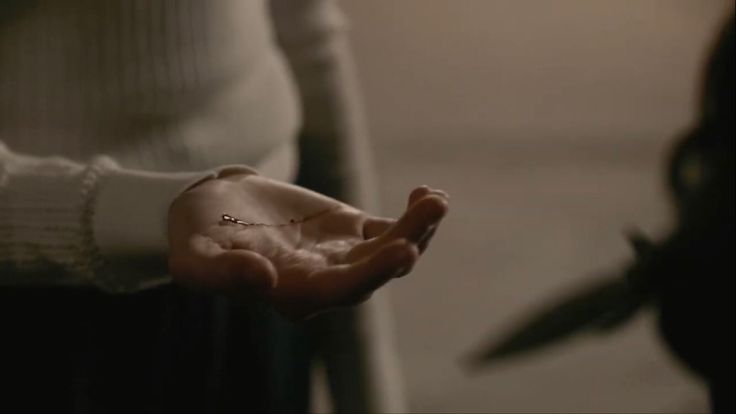 a woman holding out her hand with the word love written on it and two birds in the background