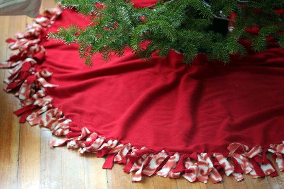 a christmas tree skirt with red and white ruffles on it, sitting on a wooden floor