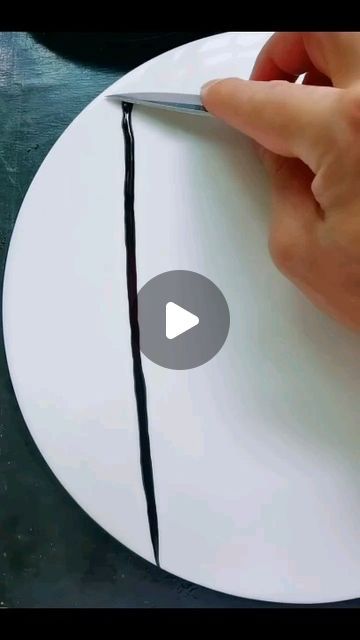 someone is cutting the edge of a piece of paper on a plate with a knife