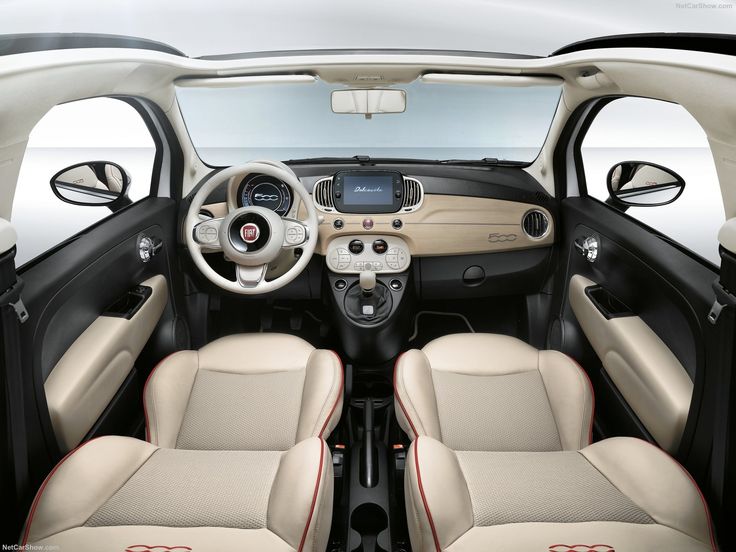 the interior of a small car with beige leather seats