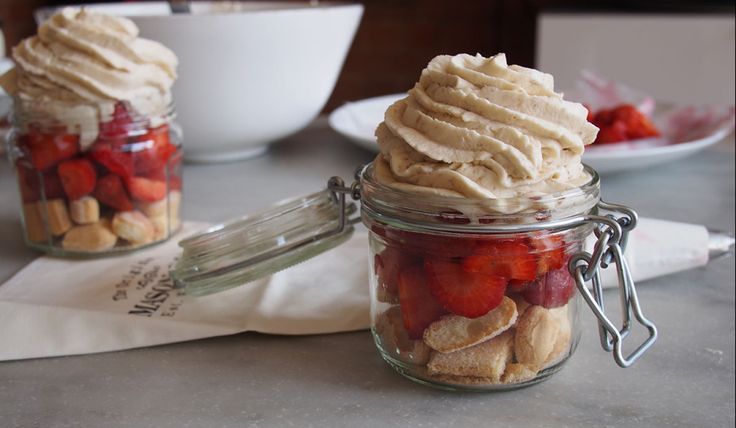 two jars filled with desserts sitting on top of a table next to each other