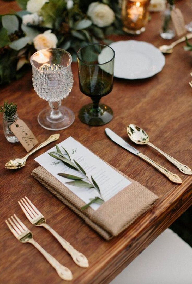 the table is set with silverware, napkins and place settings for an elegant dinner