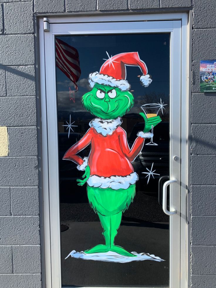 the grinch is holding a drink in his hand