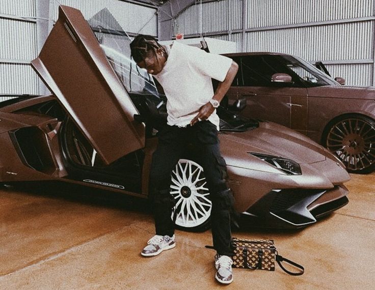 a man standing next to a car in a garage