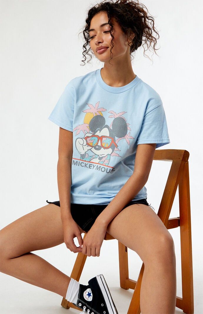 Who knew that dressing "mousey" could be so cute? Celebrate Walt Disney's most iconic character with these officially licensed Mickey Mouse and Friends styles! All of your favorites, like Mickey Mouse, Minnie Mouse, Goofy, Pluto, Donald Duck, and more, are featured across these adorable Mickey designs that are perfect for your next trip to Disneyland! The Beach Mickey Mouse T-Shirt features a crew neckline, short sleeves, and a front graphic for that classic look. Solid color teeShort sleevesCre Disney Style Tops For Summer Fan Events, Character Print Tops For Disney Fan Events In Summer, Blue Mickey Mouse Tops For Disney Fan Events, Summer Cartoon Print Tops For Disney Fan Events, Graphic Print Tops For Disney Fan Events In Summer, Cute Tops For Disney Fan Events In Summer, Character Print Tops For Summer Disney Fan Events, Trendy Mickey Mouse Tops For Disney Events, Casual Tops For Disney Fan Events With Minnie Mouse