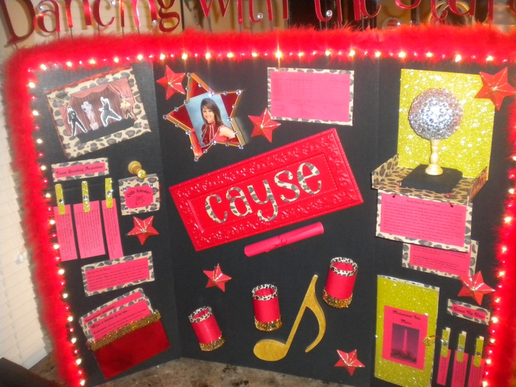 a bulletin board is decorated with red and gold decorations, such as musical instruments, stars, and music notes