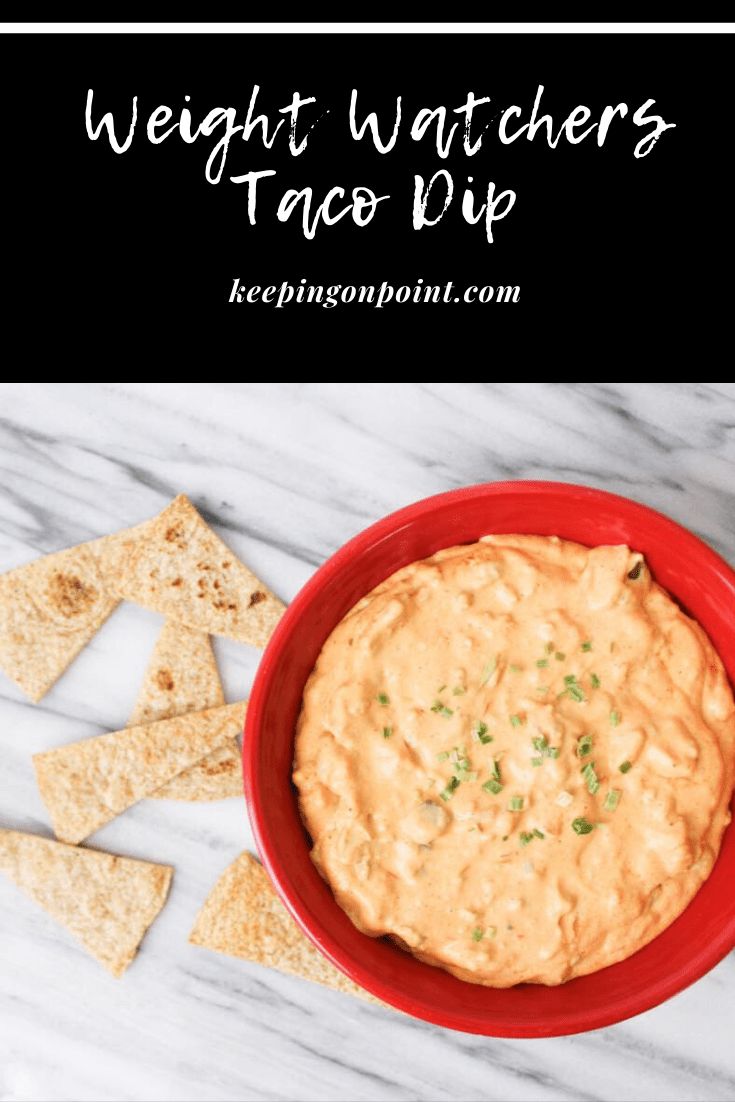 a red bowl filled with dip next to tortilla chips