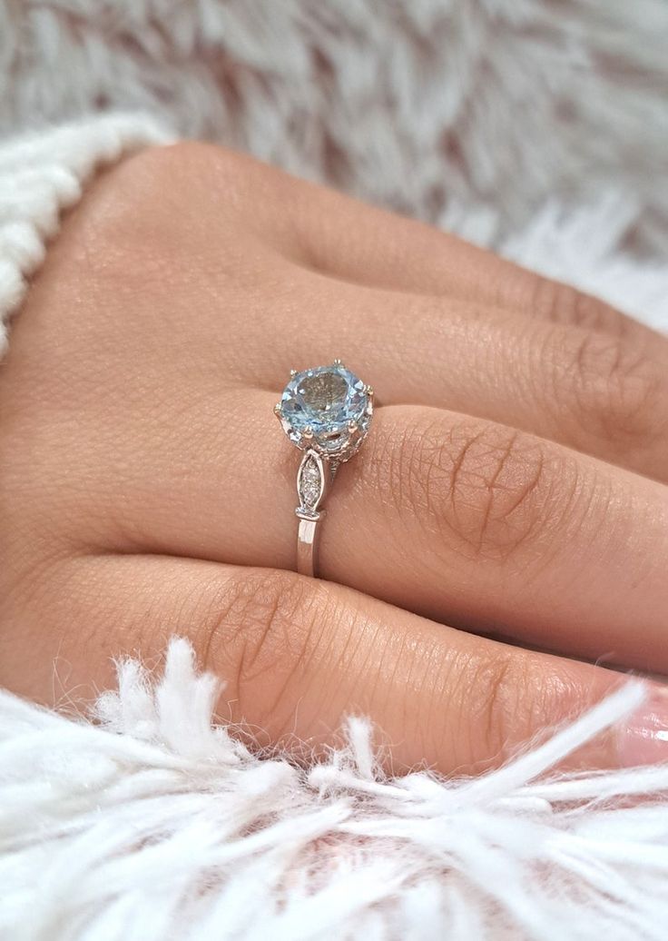 a woman's hand with a ring on it and a diamond in the middle