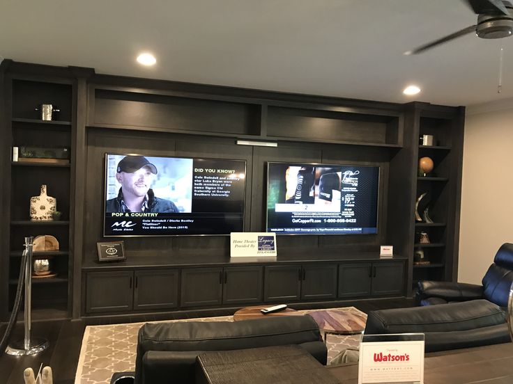 a large entertainment center with two televisions on the wall