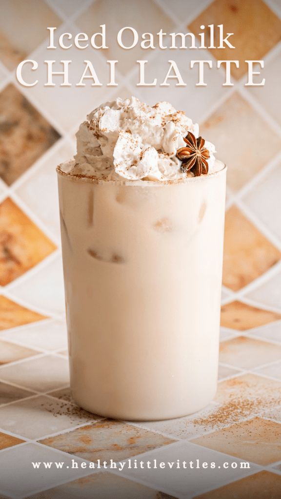 iced oatmeal chai latte in a tall glass with whipped cream and cinnamon sprinkles