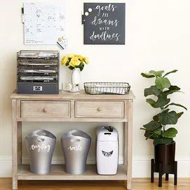 a wooden table topped with two metal trash cans